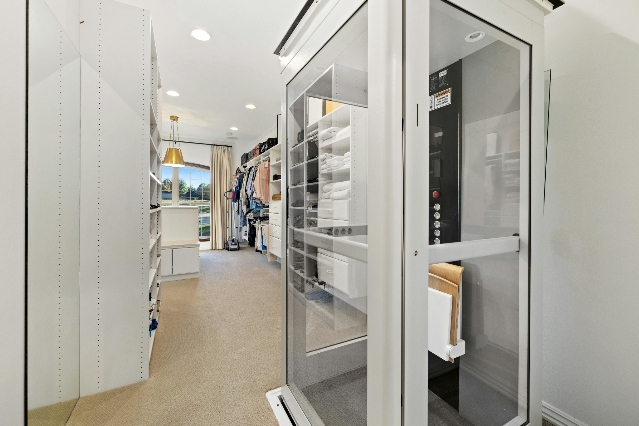 Picture of a bedroom and walk-in wardrobe with a platform lift in the centre.