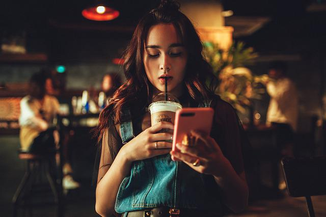 a girl drinks a cocktail and reads something