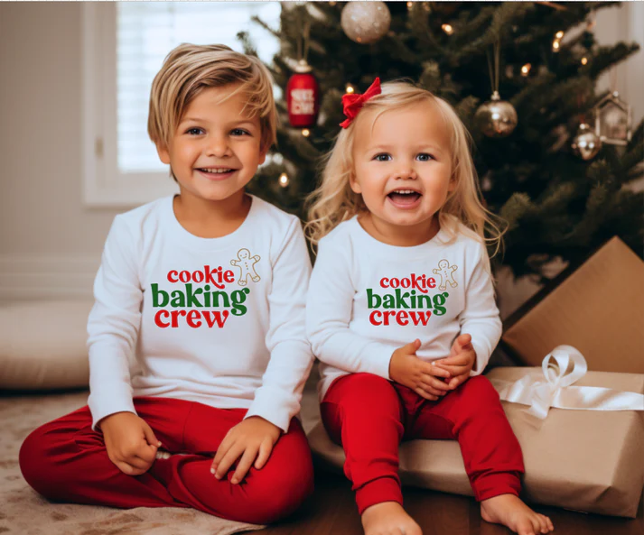 boy and girl wearing matching outfits in front of a Christmas tree