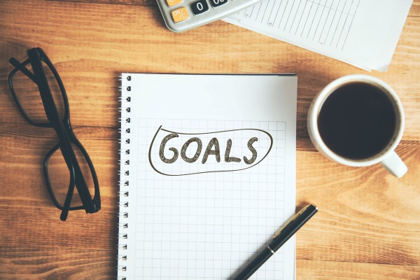 A person writing a SMART goal with a checklist