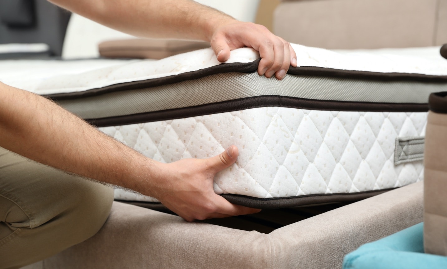 photo of white thick mattress being lifted for mattress cleaning service in singapore