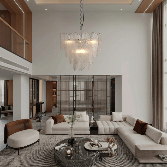 Layered glass chandelier with sculptural panels suspended in a double-height luxury living room.