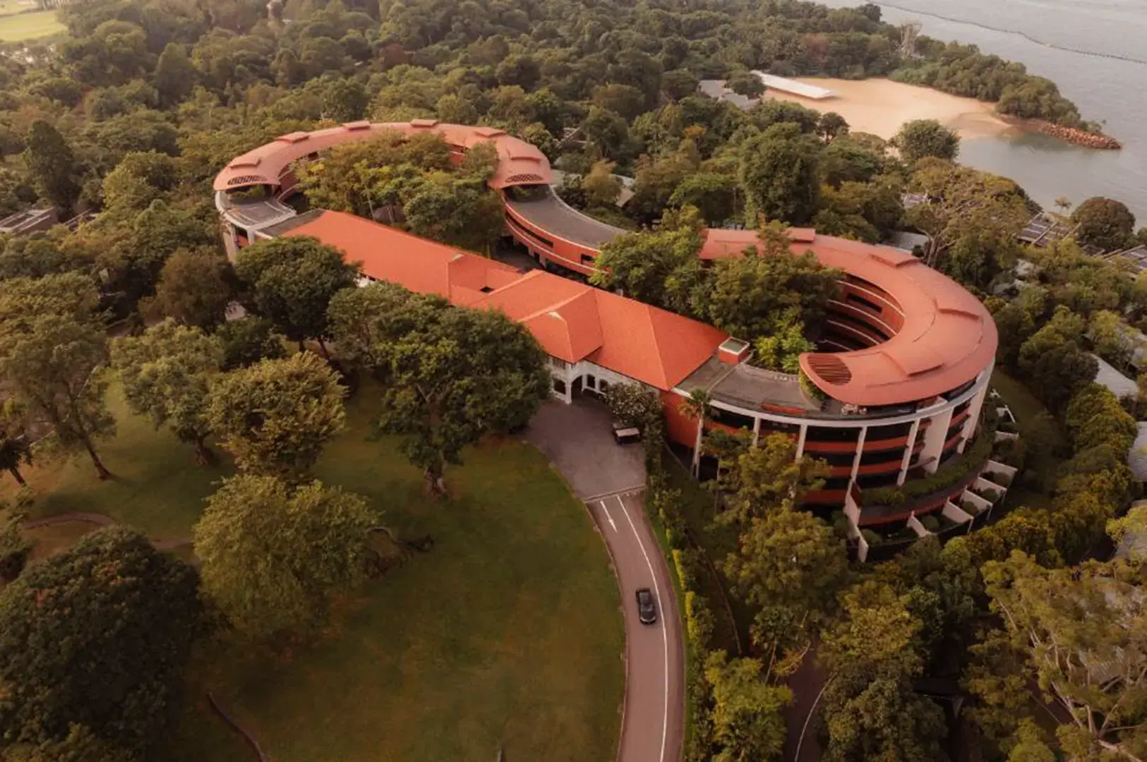 Aerial view of Capella Singapore resort with red-tiled roofs.