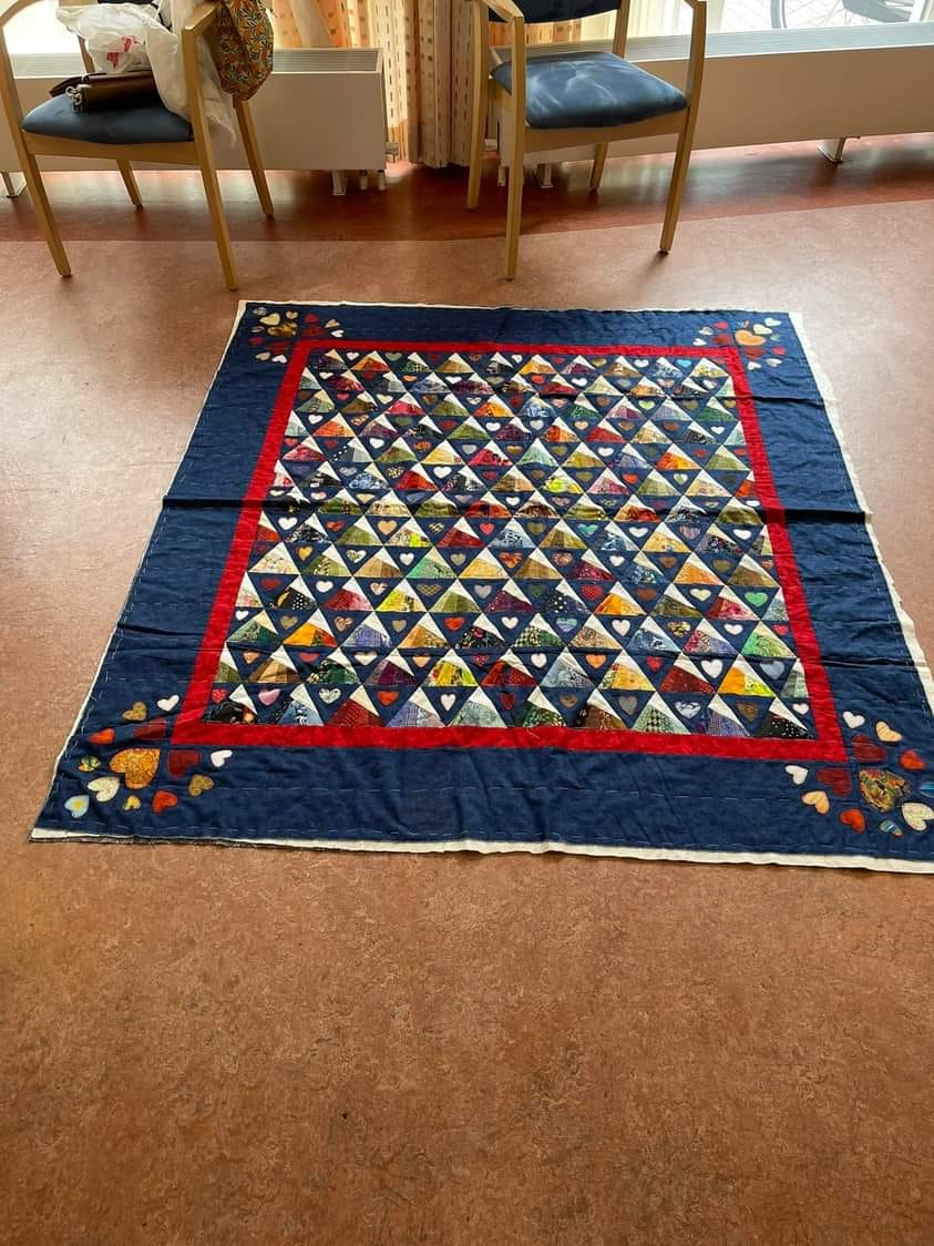 Image shows Barbara J's Scrappy Whirligig quilt using one of our quilt patterns