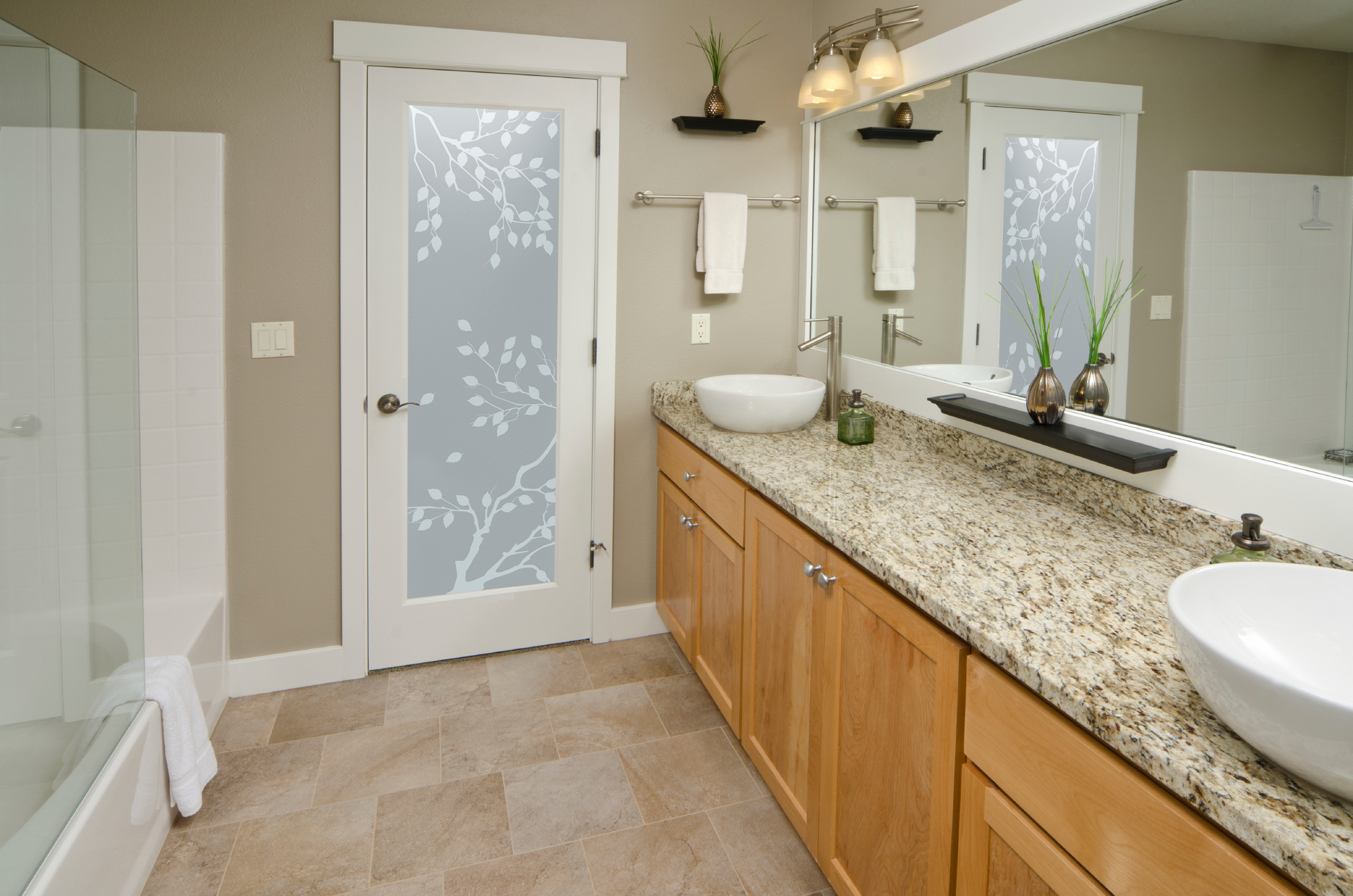 A bathroom with a private frosted glass door featuring a "Cherry Tree" design.