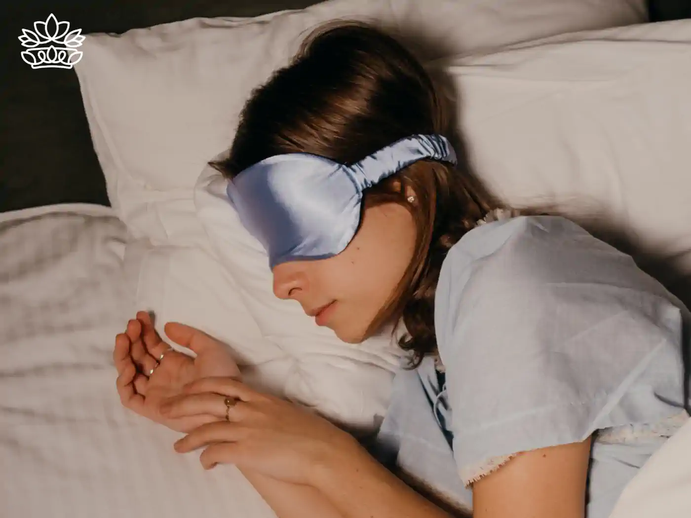 A woman sleeping peacefully with a silk eye mask, an ideal gift for better sleep health. Fabulous Flowers and Gifts - Health and Wellbeing Collection.