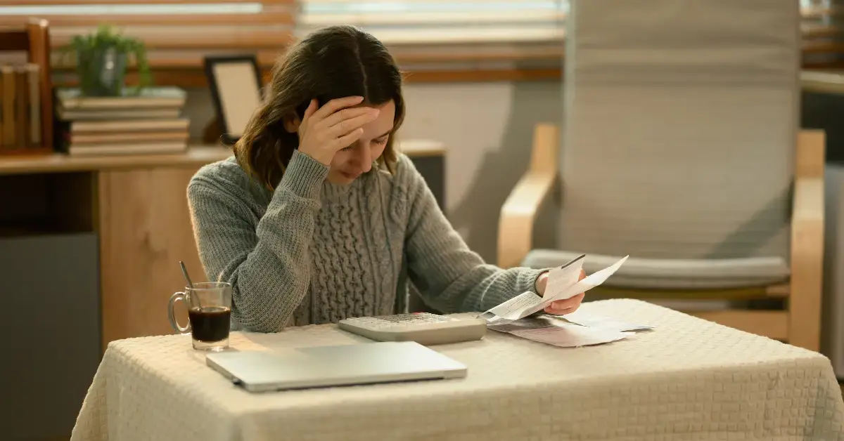 Woman reviewing tax documents and receipts, stressed about S Corp late filing penalty.