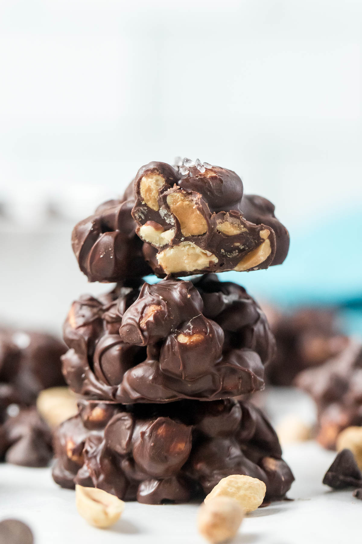 three chocolate peanut clusters stacked on top of each other