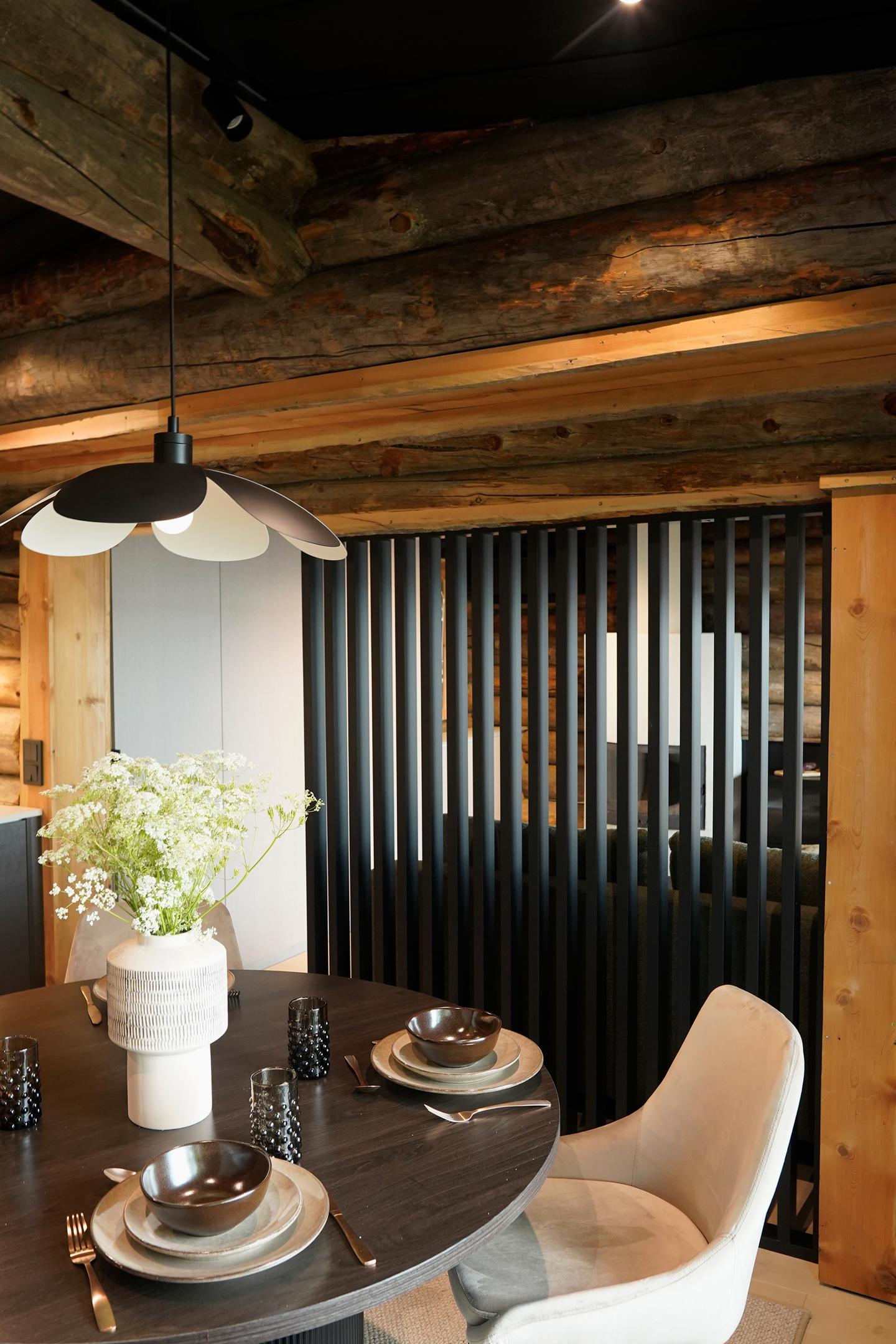 Olohuoneen ja keittiön välinen tila jaettiin tummalla rimapaneelilla.