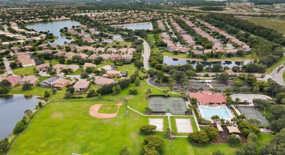 The image showcases a beautifully designed Tom Fazio championship golf course featuring immaculate fairways, serene water features, and a modern clubhouse that offers a welcoming atmosphere for golfers and residents alike. This prime location is part of a popular gated community in Fort Myers, known for its gateway real estate and various amenities, including an Olympic-sized swimming pool and fitness center.
