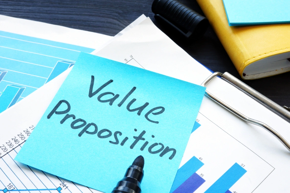 A blue sticky note with the words "Value Proposition" written in black markers, raising a question like "How to value a business quickly?" .