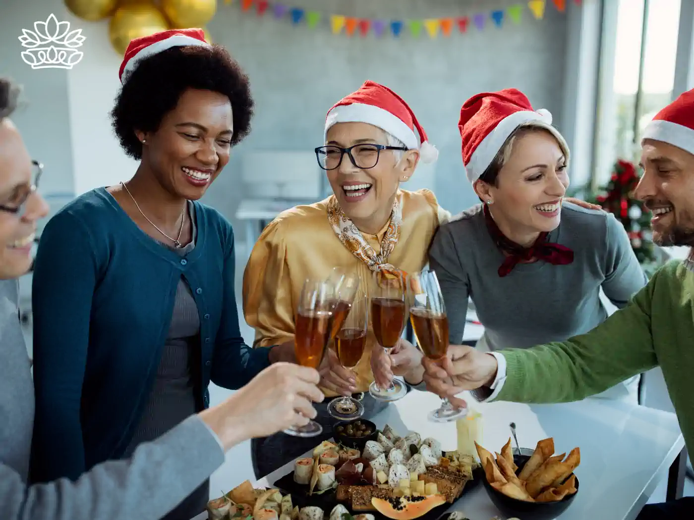 Friends in Santa hats toasting with champagne, enjoying a festive spread, surrounded by cheerful decorations, part of the Festive Season Flowers Collection. Delivered with Heart by Fabulous Flowers and Gifts.