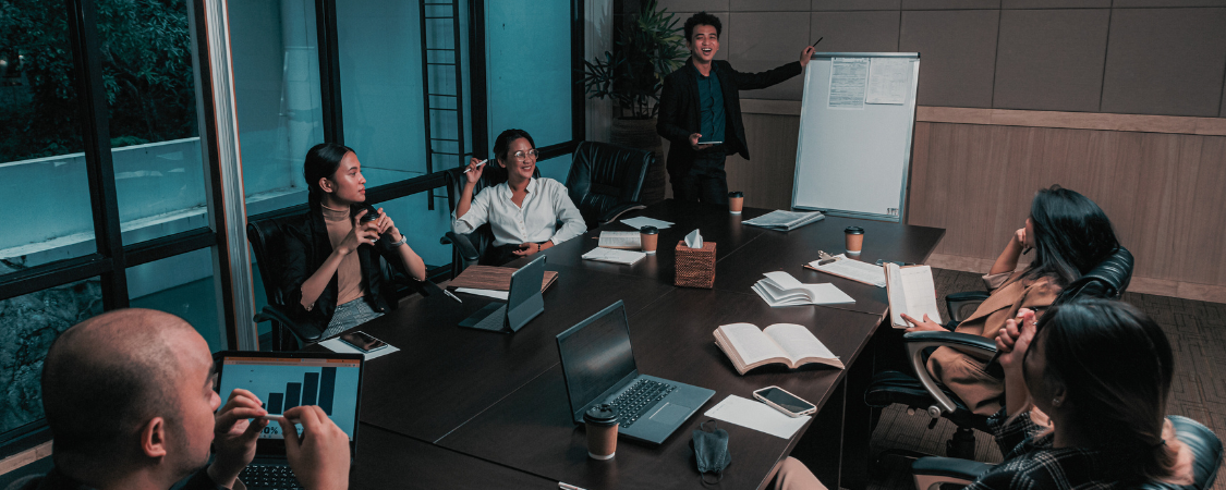 Imagem: Uma equipe de executivos sentados em uma sala de reuniões discutindo estratégias de vendas.  ALT: Reunião de executivos discutindo estratégias de vendas para impulsionar o crescimento do negócio.