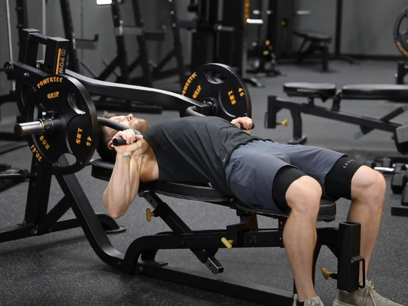 Image of an athlete targeting different muscle groups using the incline machine press feature.