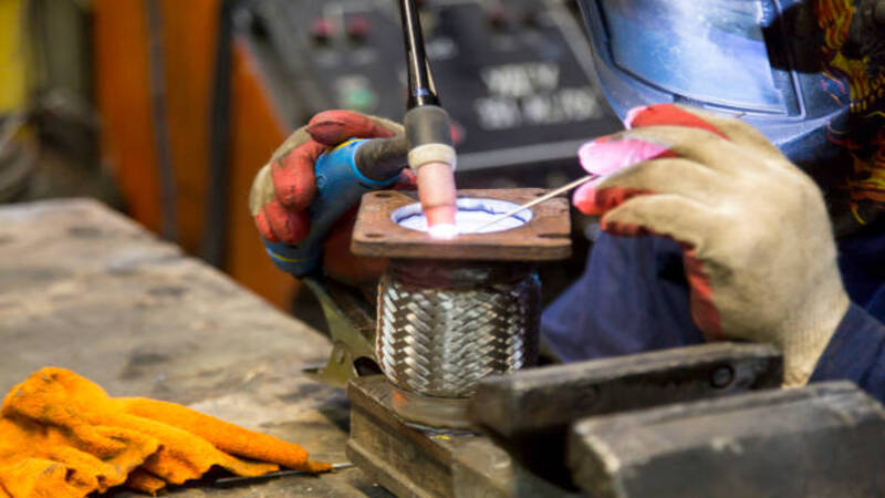 A welding expert using handheld laser welding machine for welding metals. 