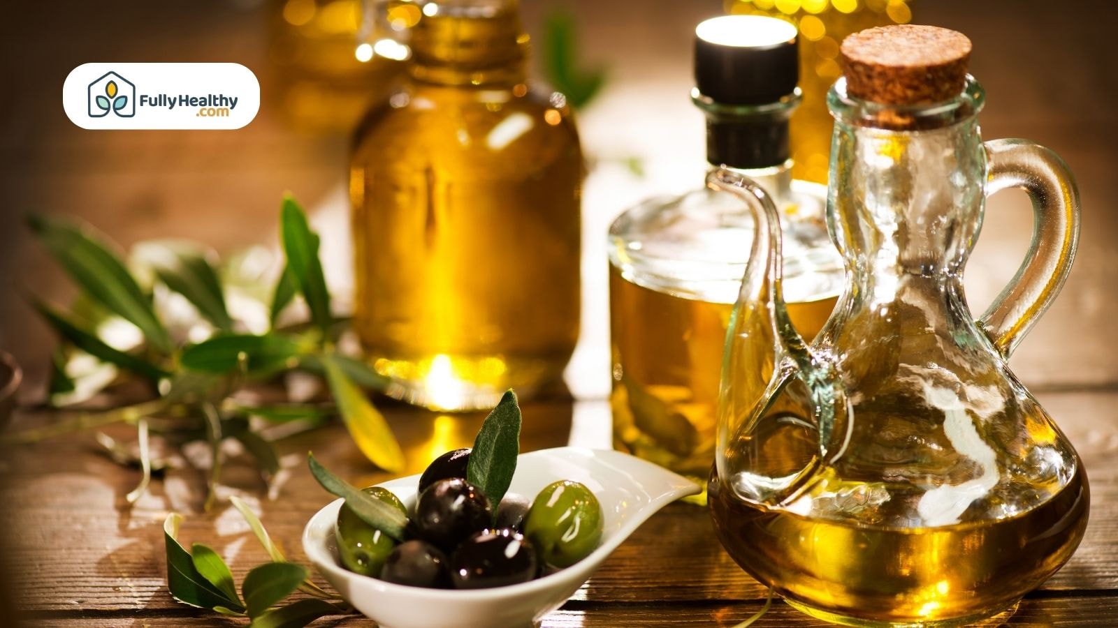 Assorted olive oil bottles and fresh olives on wooden surface
