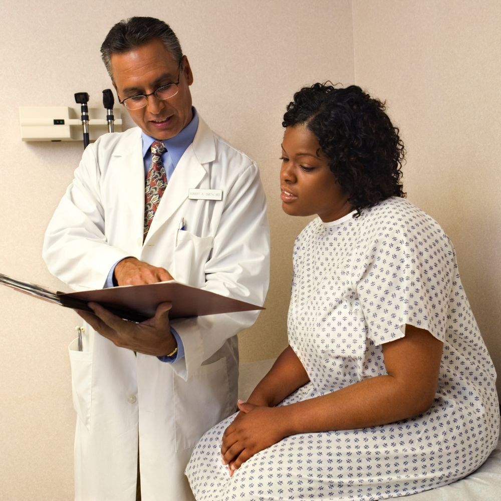 A person talking to a doctor, illustrating the importance of discussing interactions with other medications and health conditions with a healthcare provider