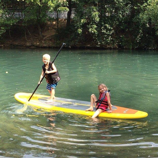 two children on a stand up paddle board