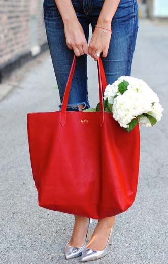 a girl wearing blue jeans with her red handmade Cuyana tote bag