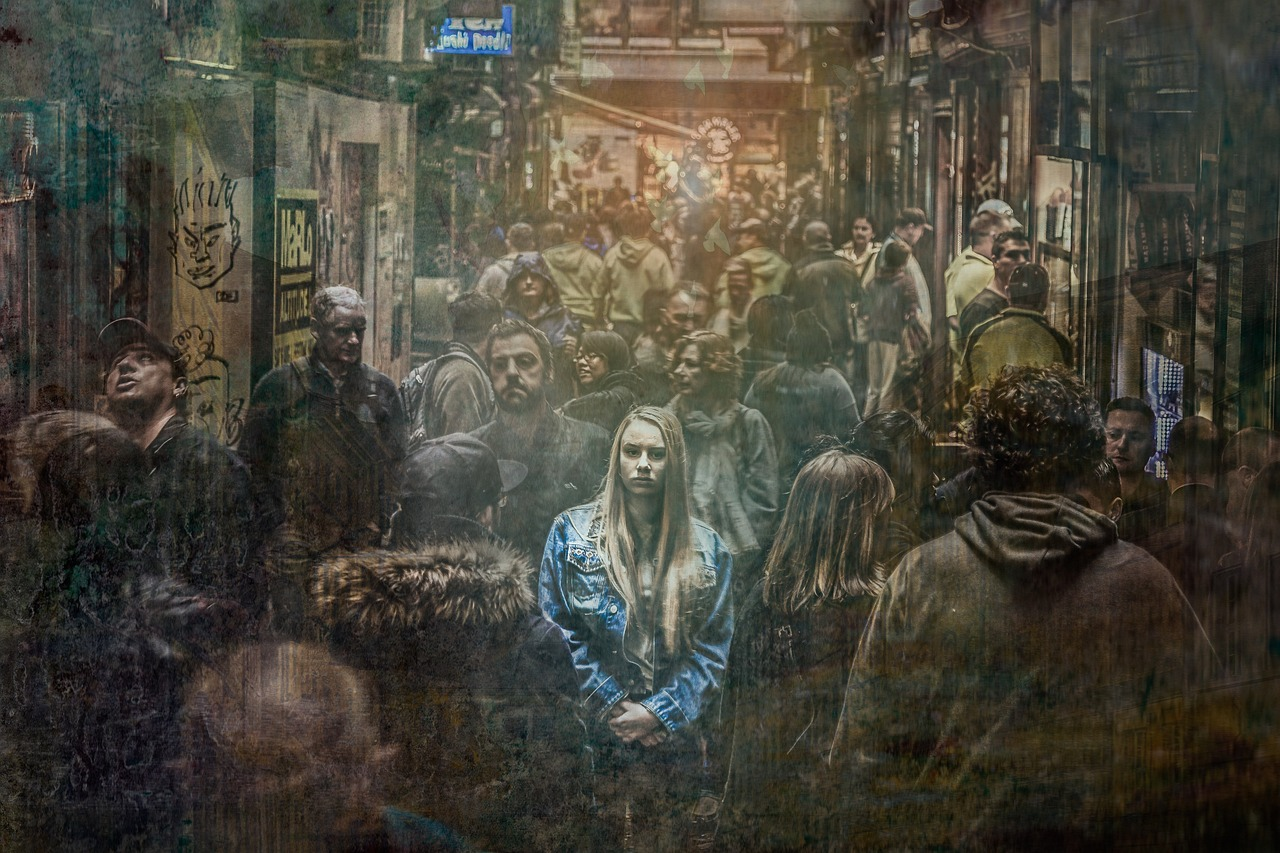 Woman looking apprehensive in an oppressive crowd at night.