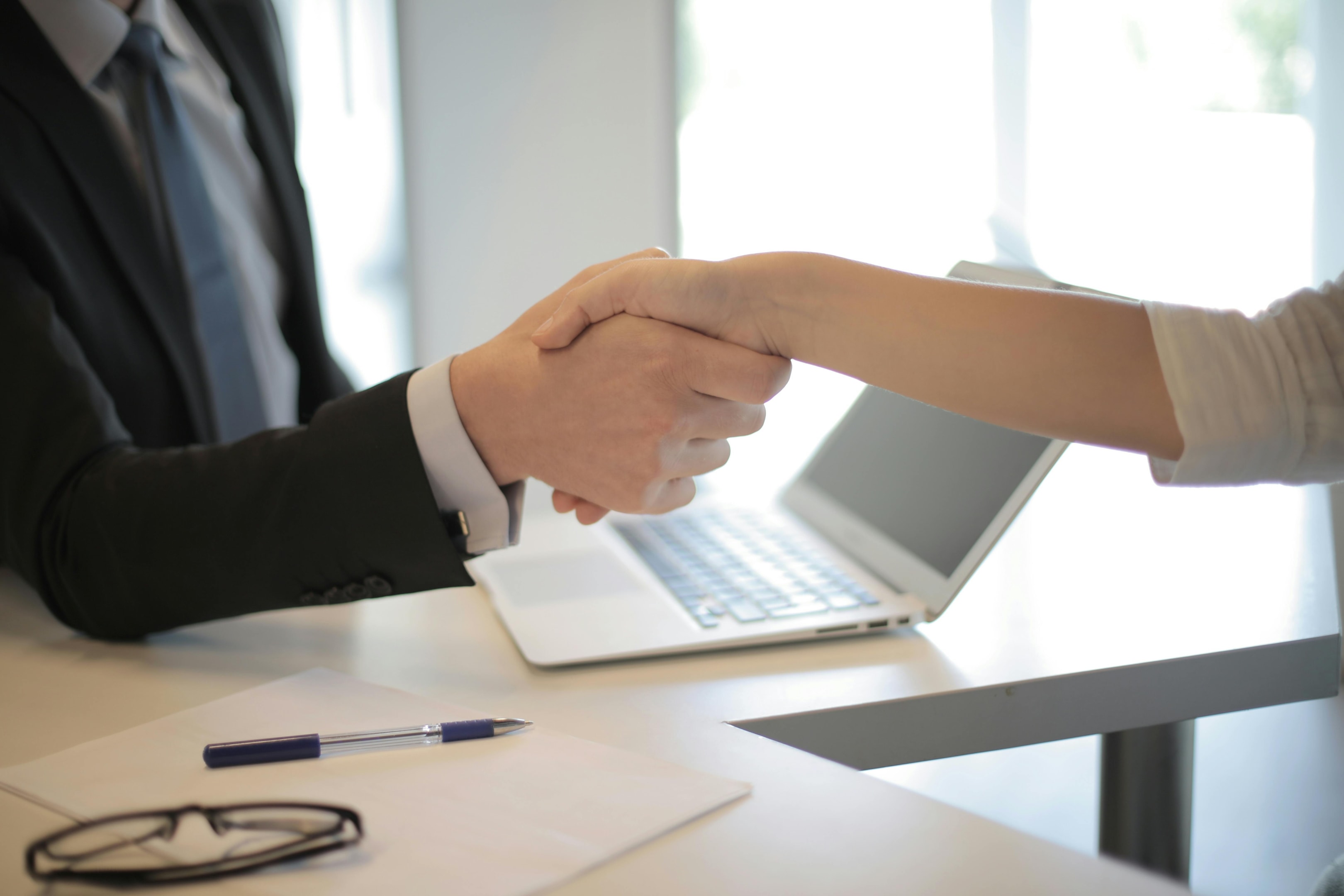 Real estate investor shakes hand of home seller. 