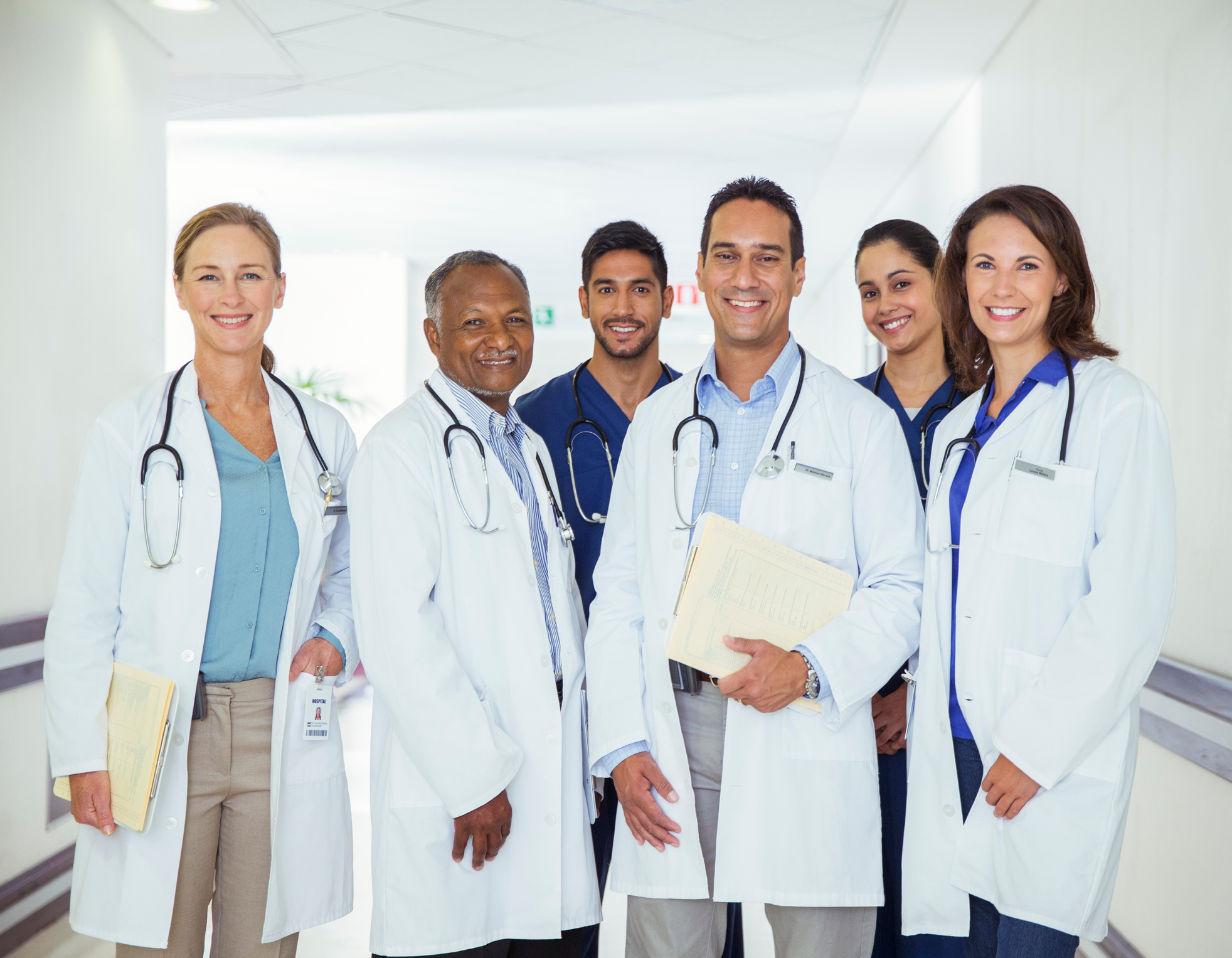 An image of male and female doctors standing in a hallway. 