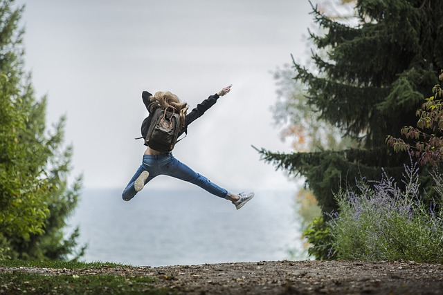 Pexels from Pixabay. Woman with backpack jumping in air, feeling happy, and moving forward. 