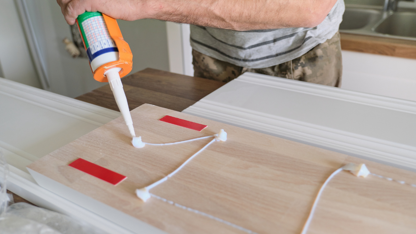 Mann trägt Kleber auf Holz auf
