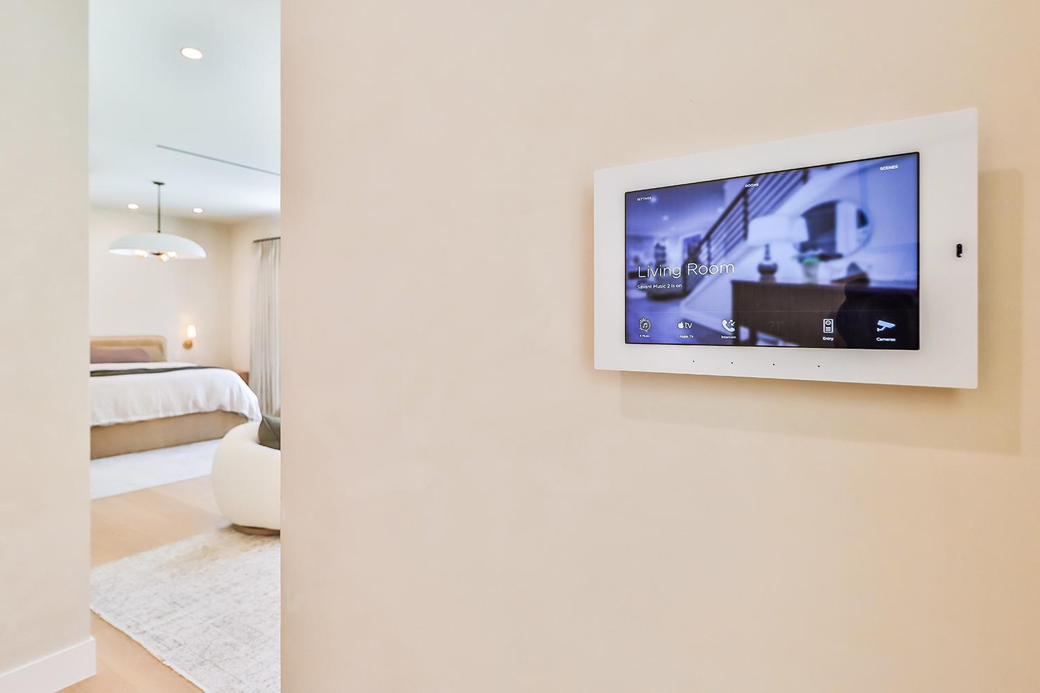A modern entryway features a sleek smart home touchscreen control panel mounted on the wall, serving as a central hub for managing various smart home devices and systems. This advanced technology enhances convenience and energy efficiency, allowing homeowners to seamlessly integrate smart home automation into their daily lives.
