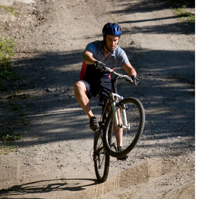 A mountain biker preloading and pulling up to master the wheelie technique