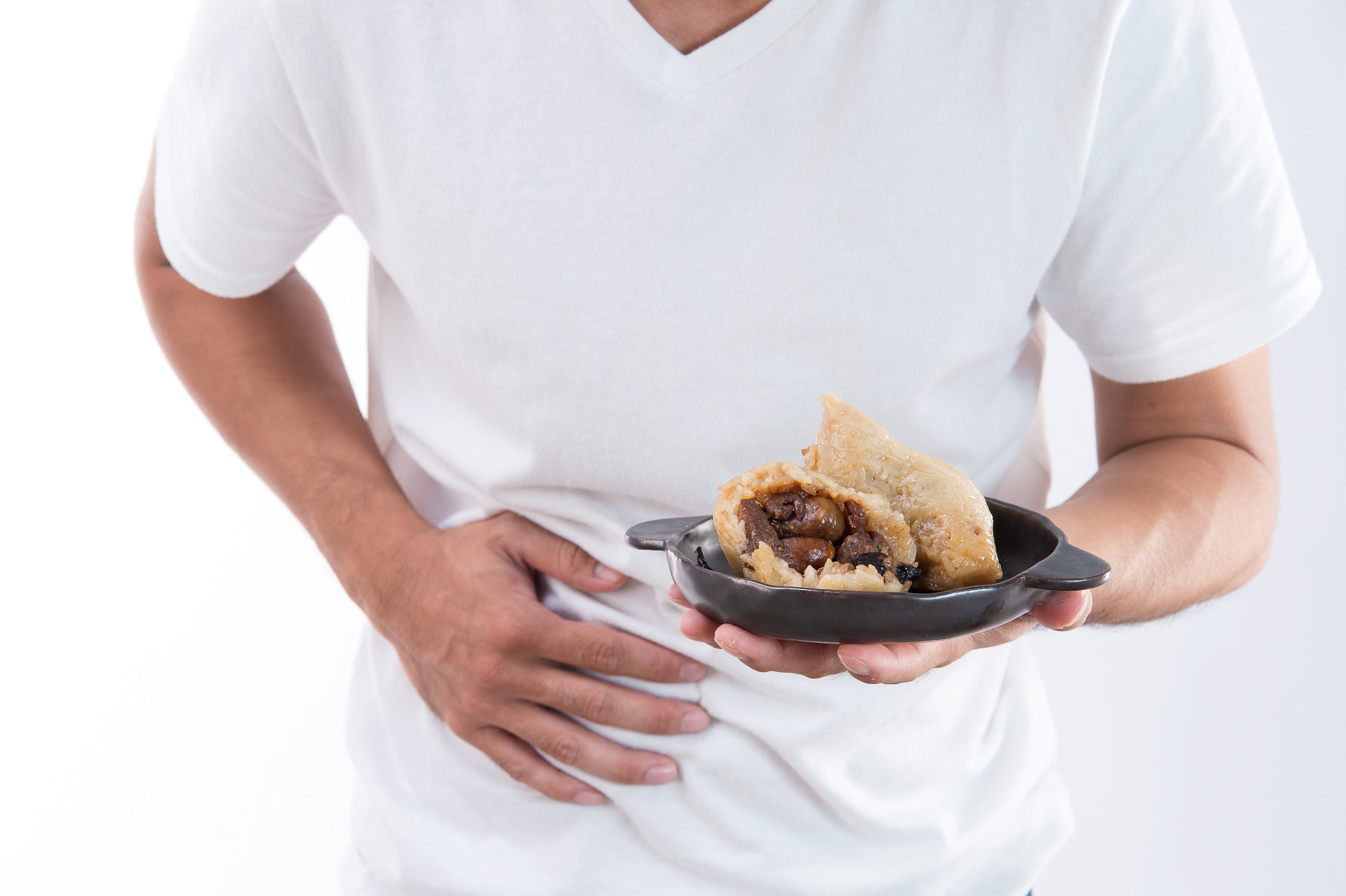 A man holds his stomache in pain after he suffered food poisoning from a meat pie