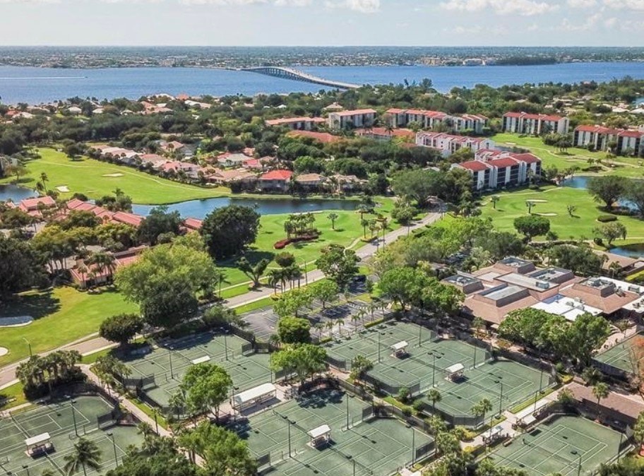 An aerial view of The Landings gated community in Fort Myers showcases stunning waterfront properties, a lush golf course, and a marina along the Intracoastal Waterway, highlighting the luxurious lifestyle and diverse amenities available in this vibrant community. The image captures the essence of southwest Florida living, featuring well-maintained homes and recreational facilities.