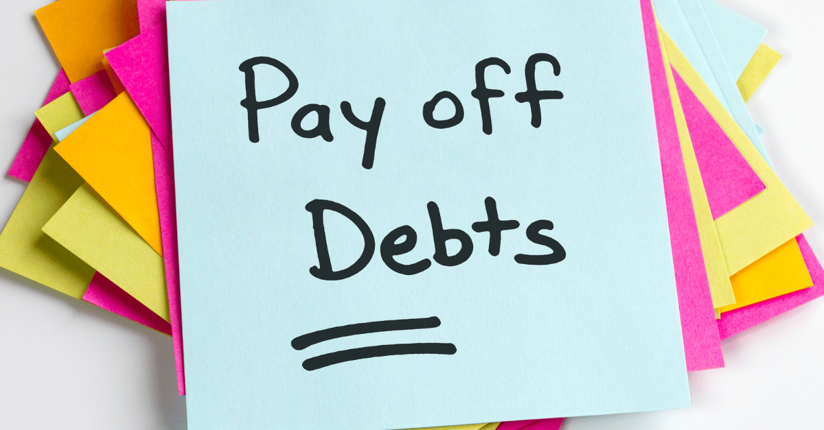 A sticky note highlighting to pay off debts 