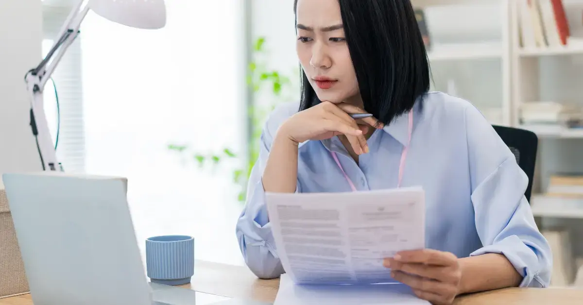Woman creator reviewing IRS Form 12277 and a federal tax lien notice at her desk.