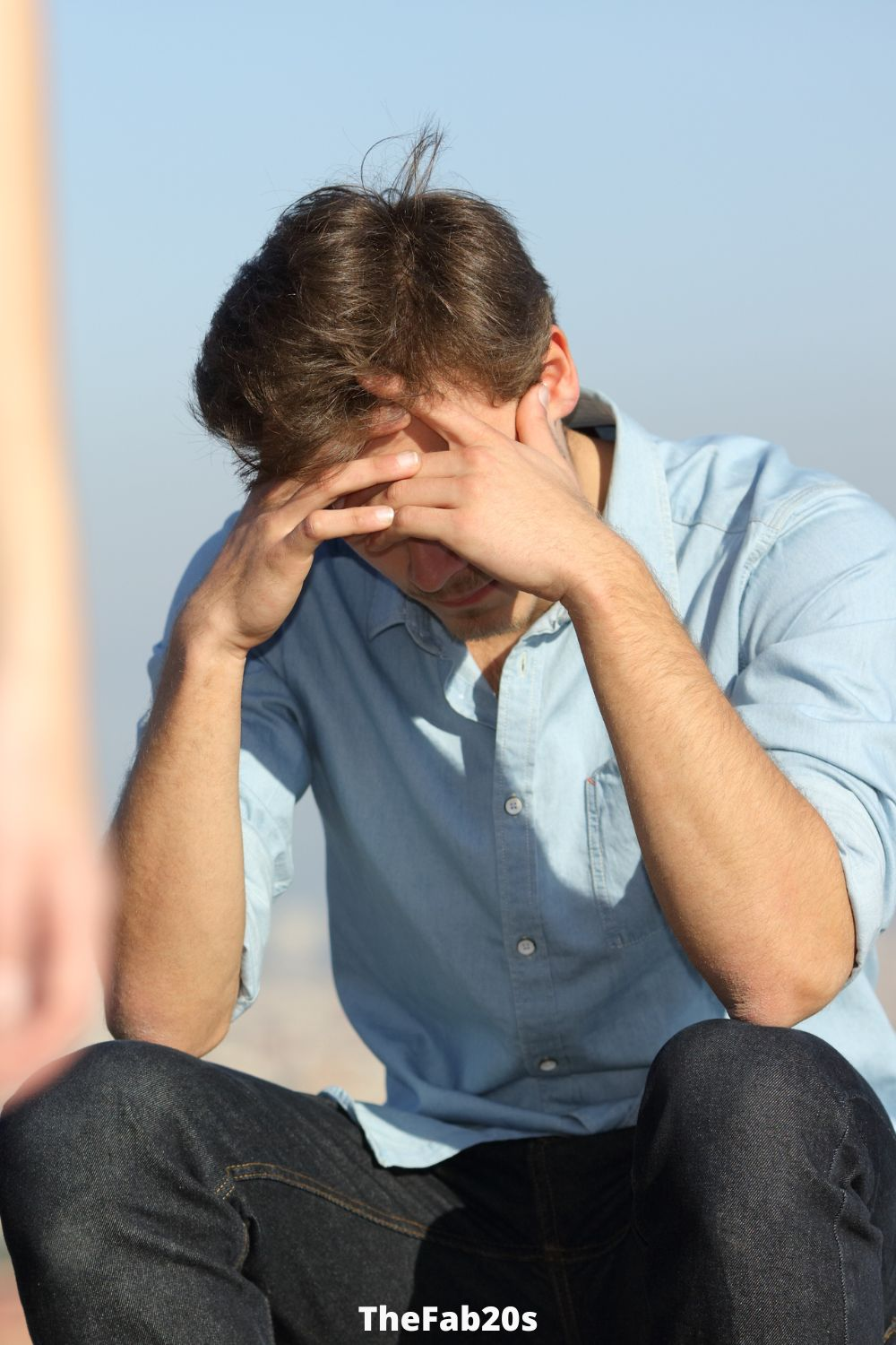 Man upset, with his face in his hands