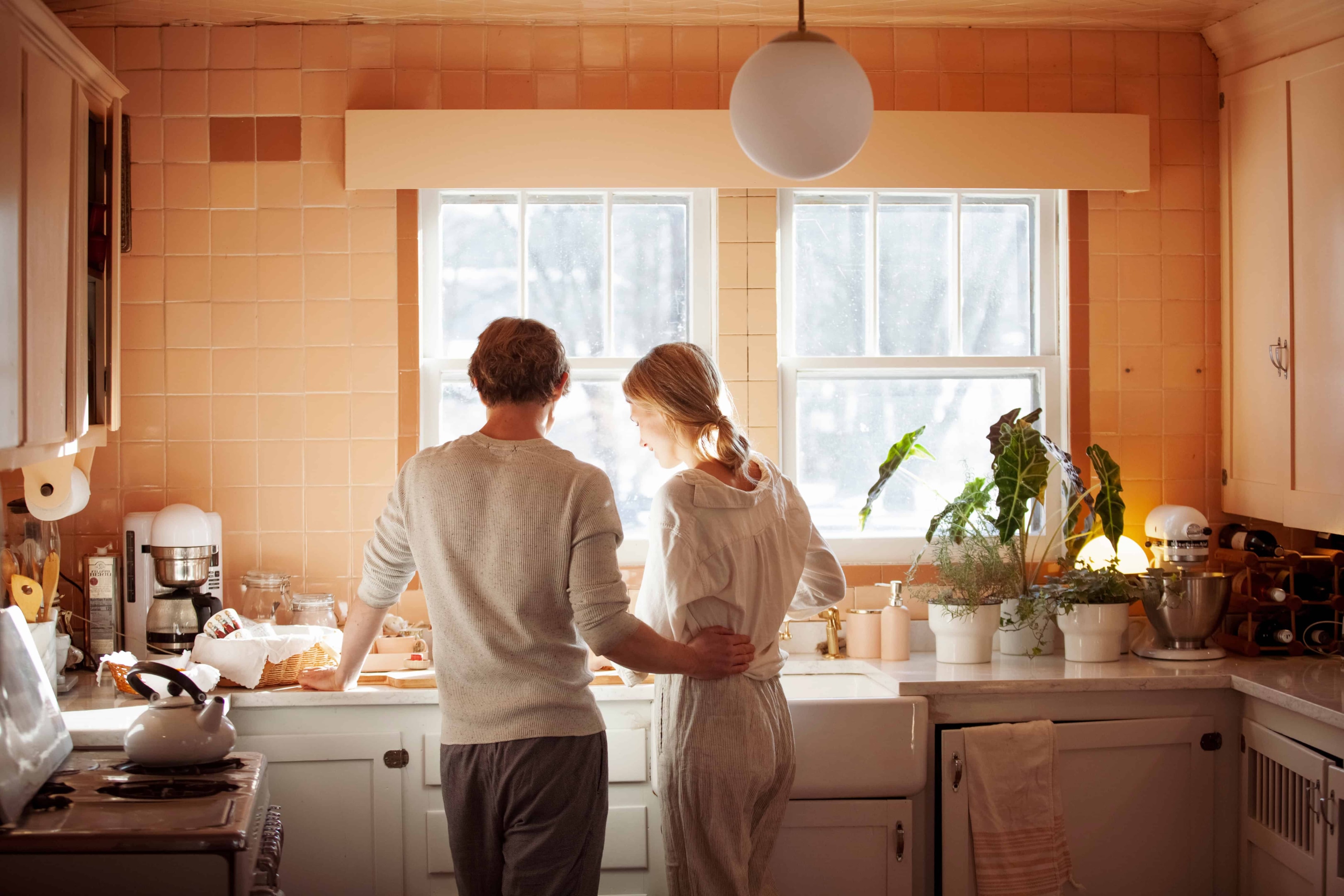 A couple in the kitchen touching and loving each other.