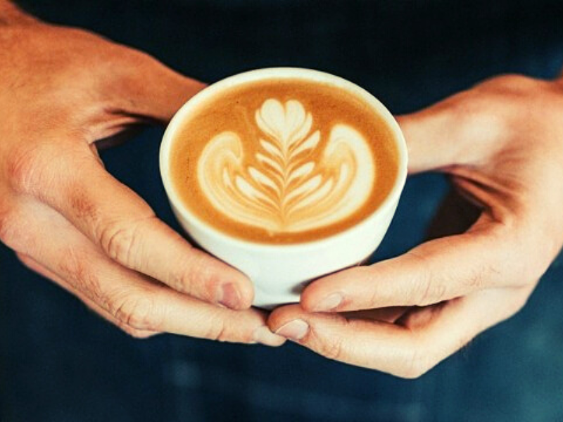 Homem segura xícara com latte art das cafeterias da Prestinaria. Foto: Reprodução: instagram.com/prestinaria/