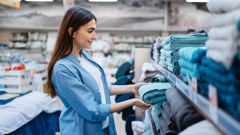 A woman buys towels at the supermarket