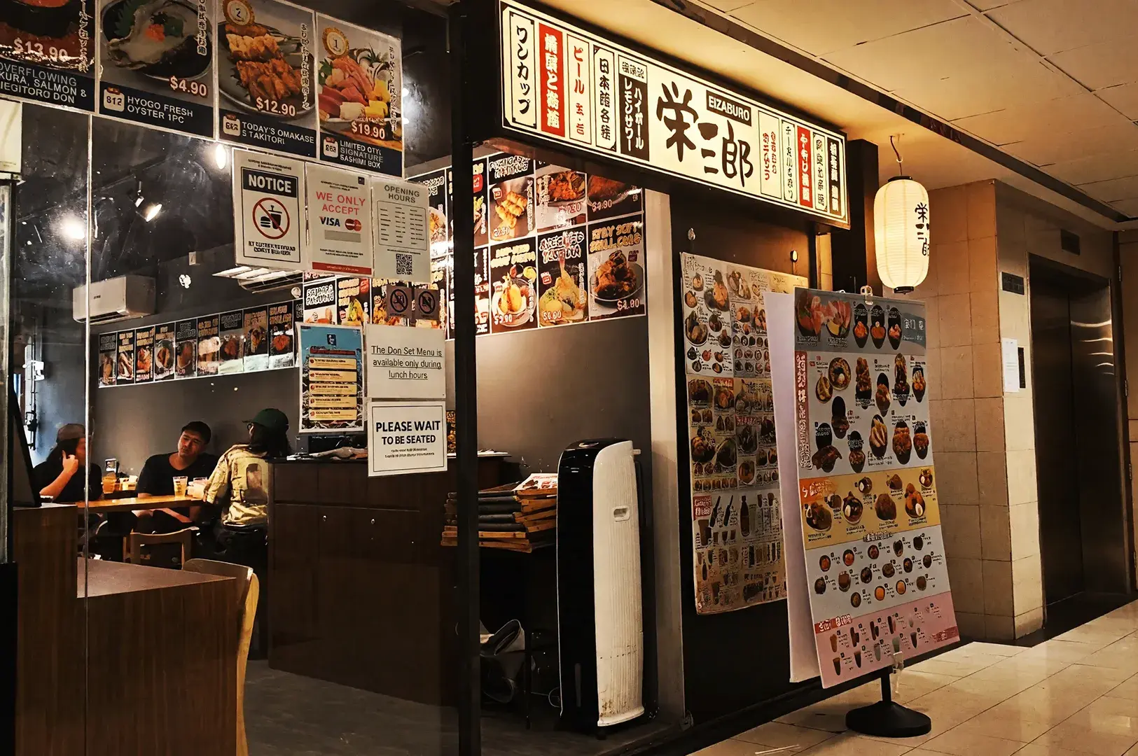 Exterior view of Sakedoro Eizaburo Japanese restaurant at Fortune Centre, featuring a backlit sign, menu displays, and entrance signage.