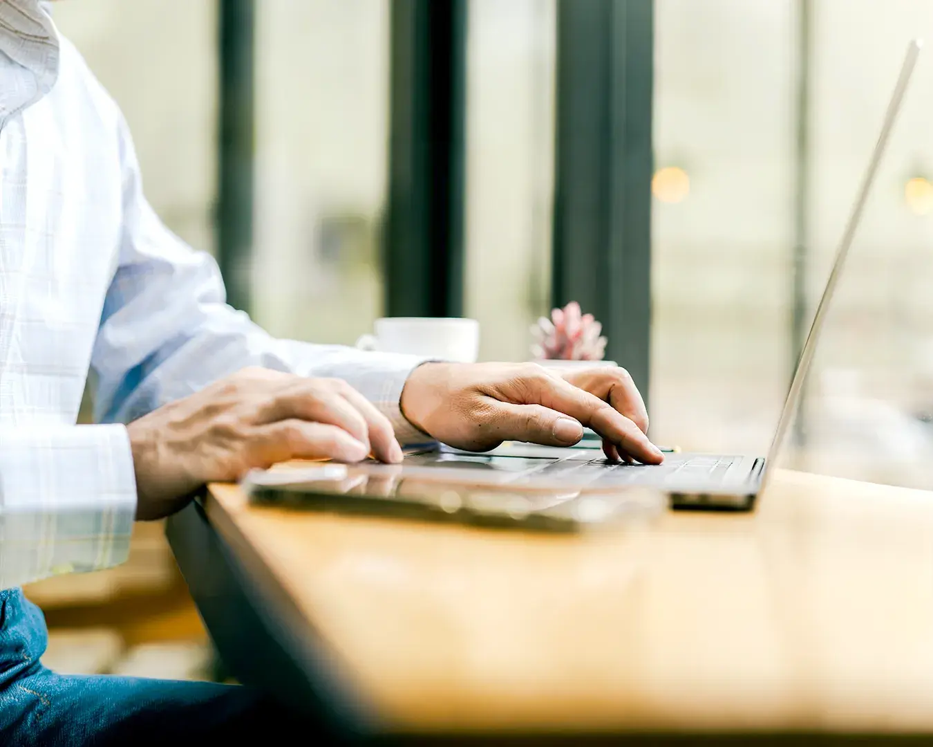 Hospitality business owner reviewing restaurant email marketing automation dashboard on laptop in bright café