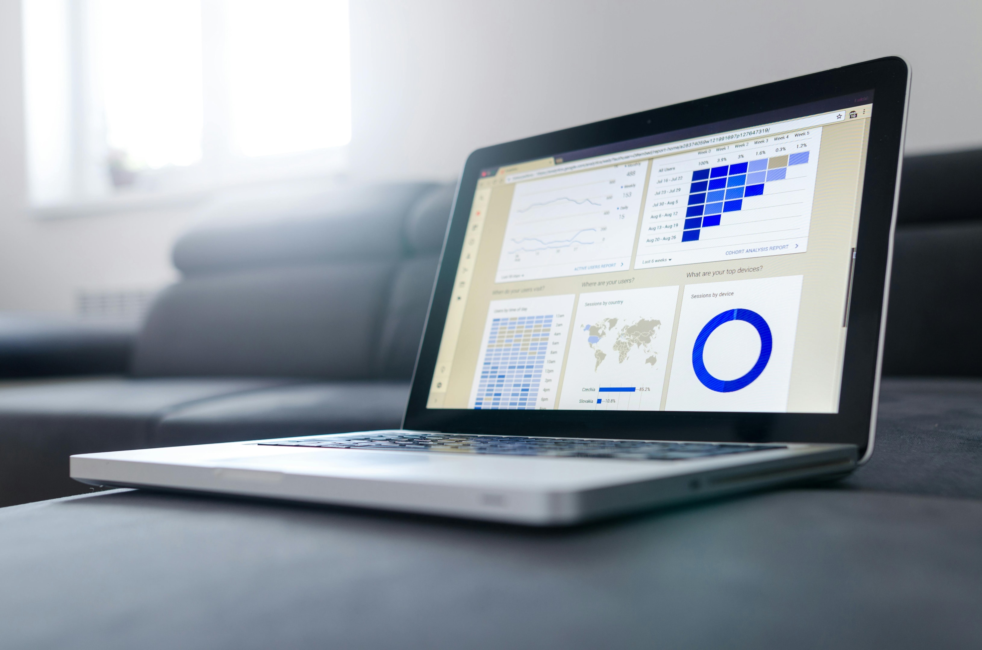 Real estate investor tracks demographic analytics with software on laptop.