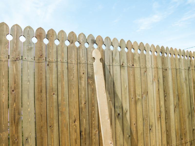 An image showing a perfect professionally installed fence with one piece left to be completed.