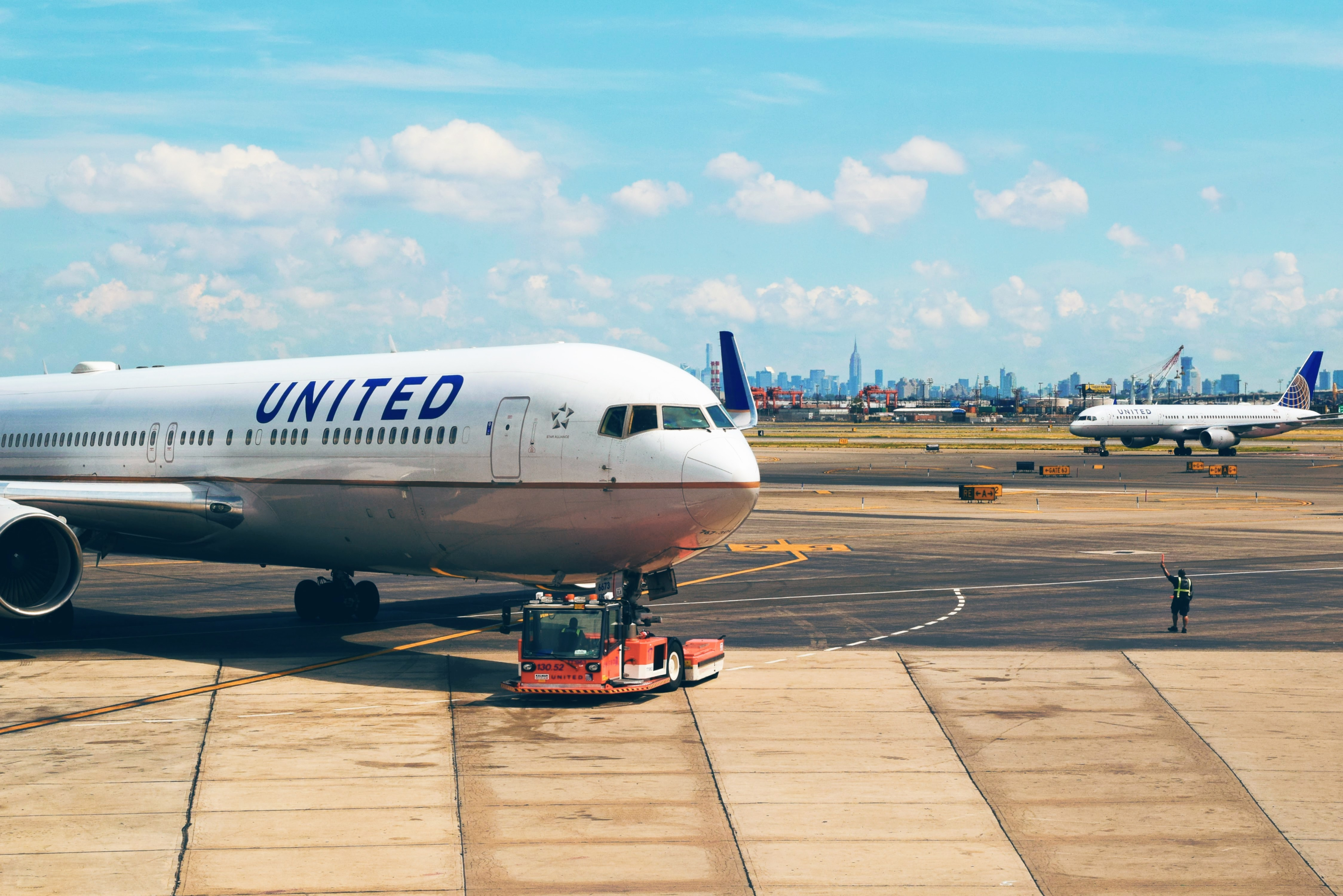 United Airlines aircraft being towed across taxi routes at an airport. Best airline to work for as a flight attendant.