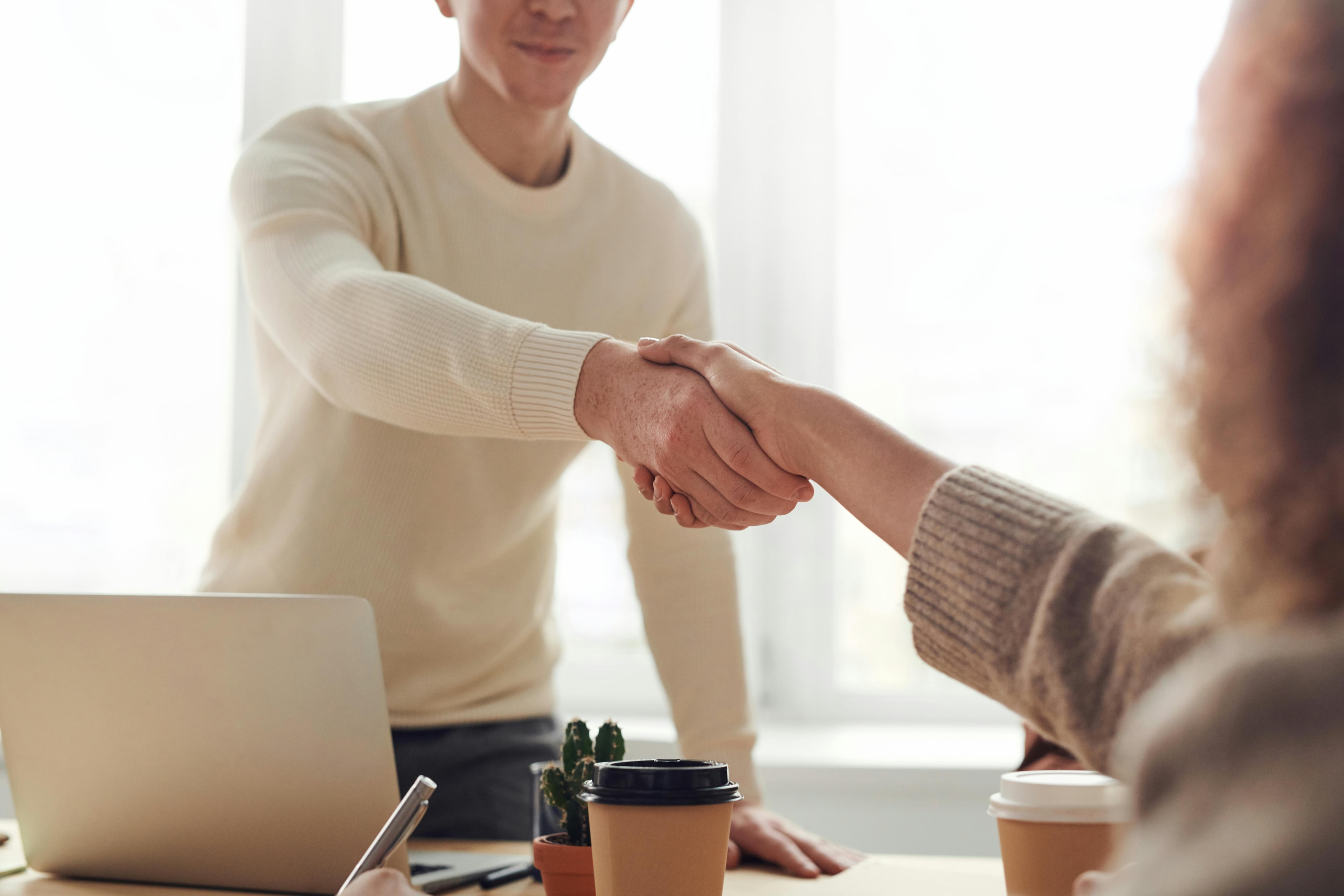 Real estate investor shakes hand of home seller. 