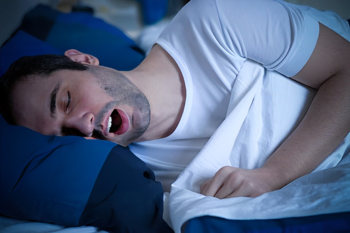 A photo of a man snoring while sleeping