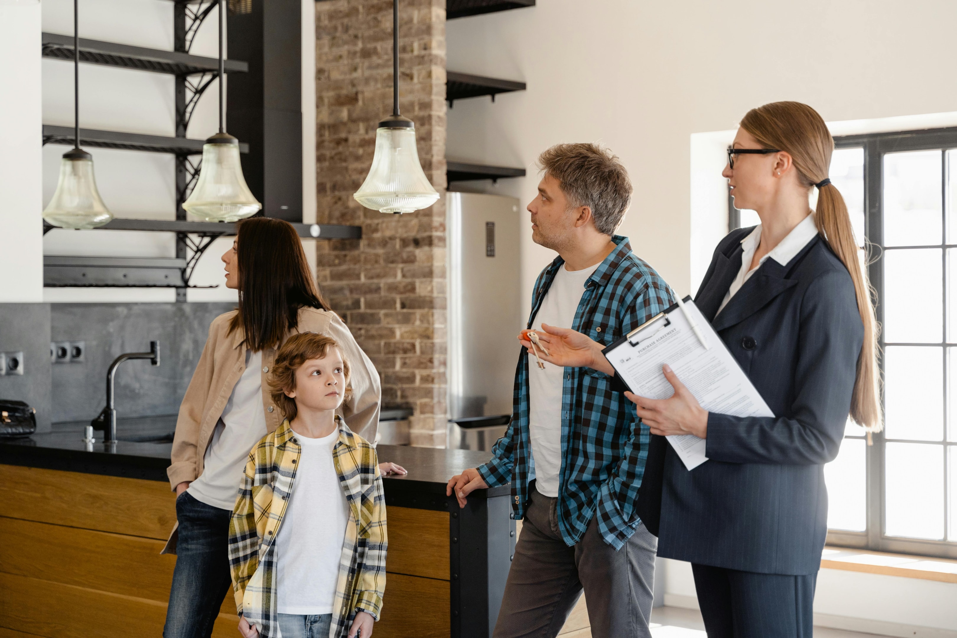 Real estate agent shows family remodeled kitchem during open house.