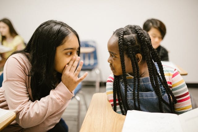 Two schoolgirls gossiping 