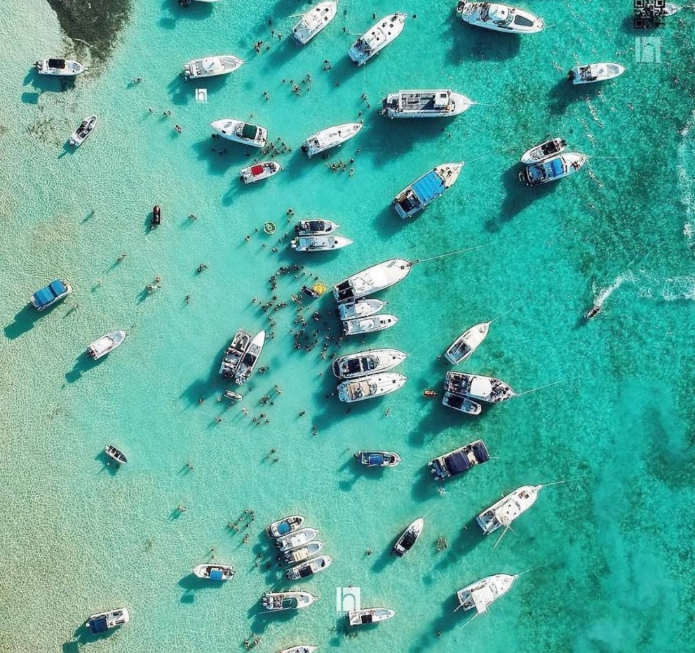 aerial view of several boats moored on clear water