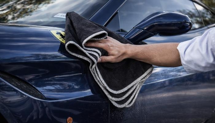 A chamois cloth is being used to clean the high-gloss paint