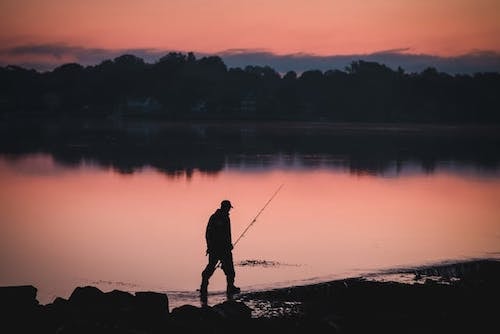 Fisherman walking along the coast of Long Island Sound at Greenwich Point Park